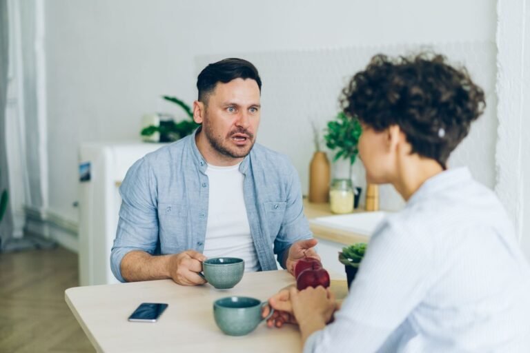Casal conversando à mesa, com café