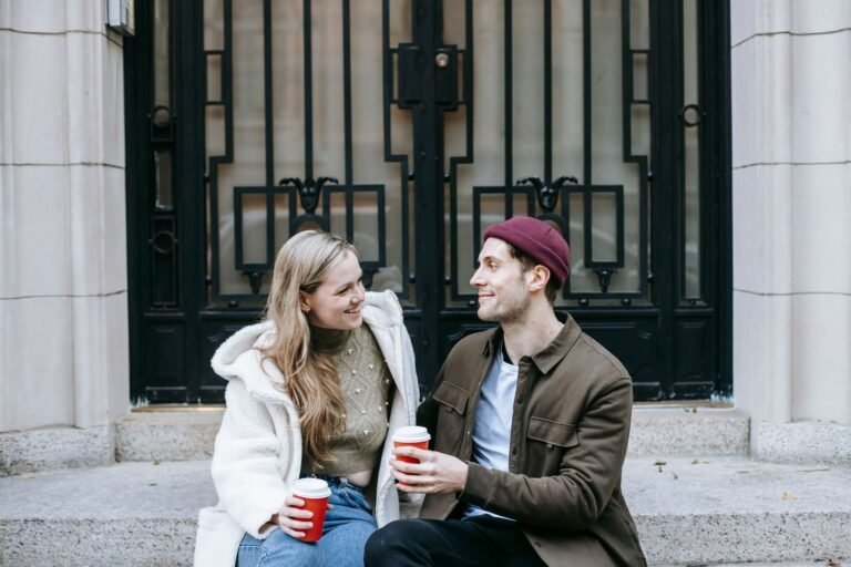 Casal sentado na calçada, conversando com café